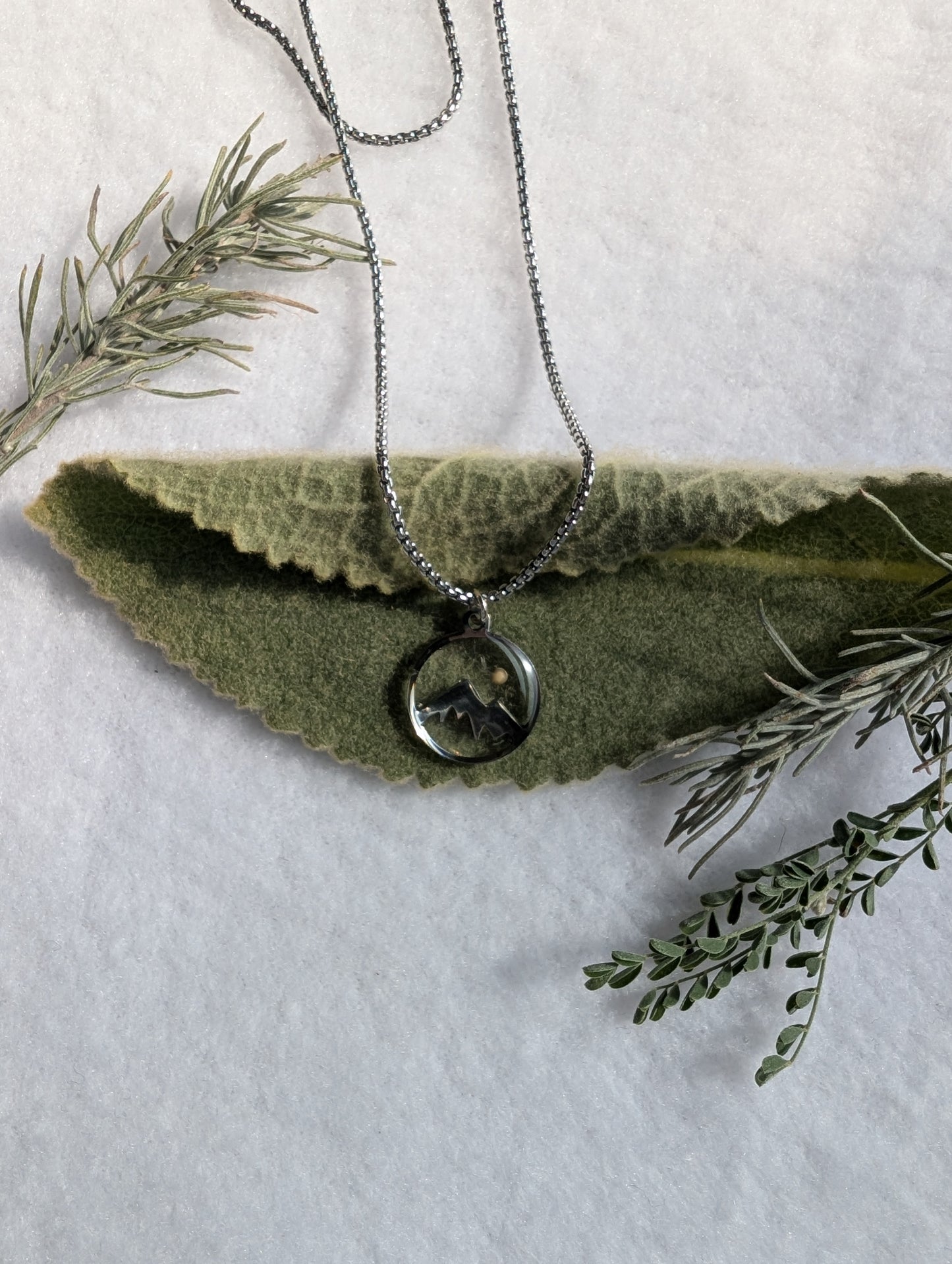 Silver mountain mustard seed pendant on a long antique silver chain