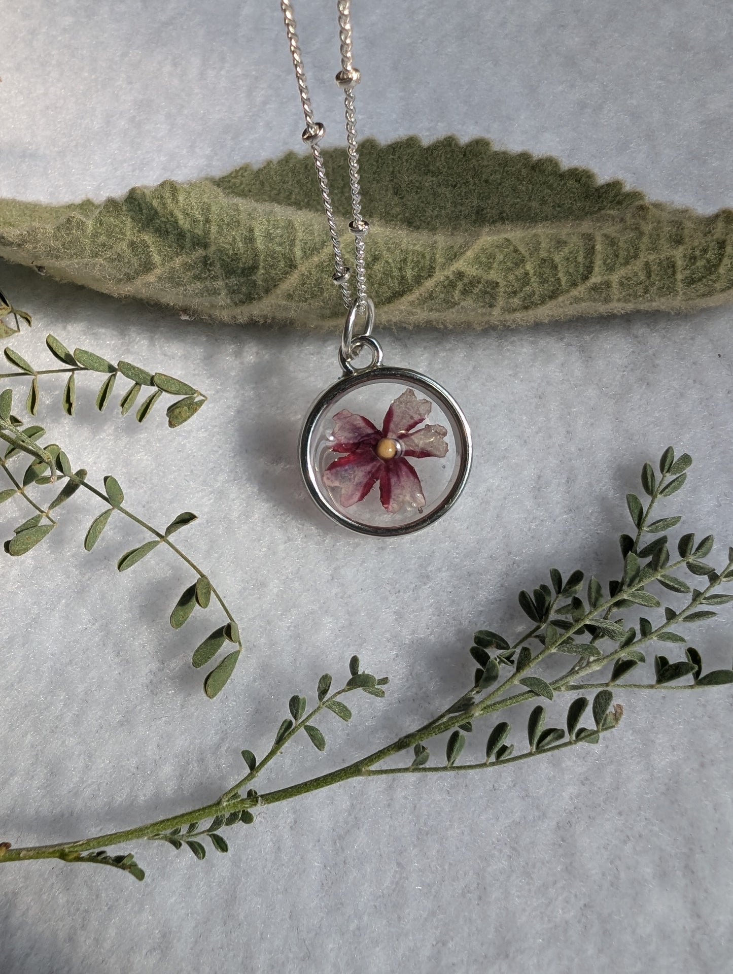 Burgundy flower mustard seed necklace on embellished long silver chain
