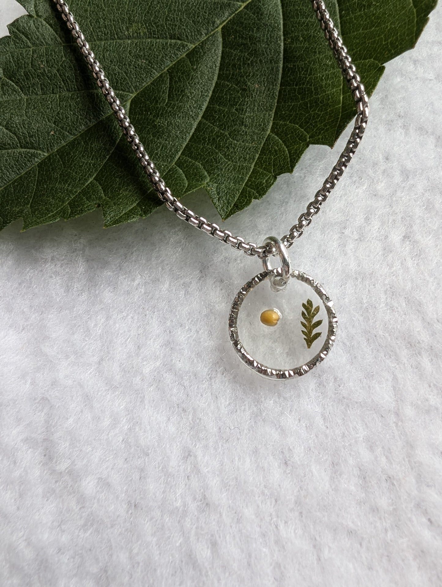 Textured small mustard seed pendant on long antique silver chain
