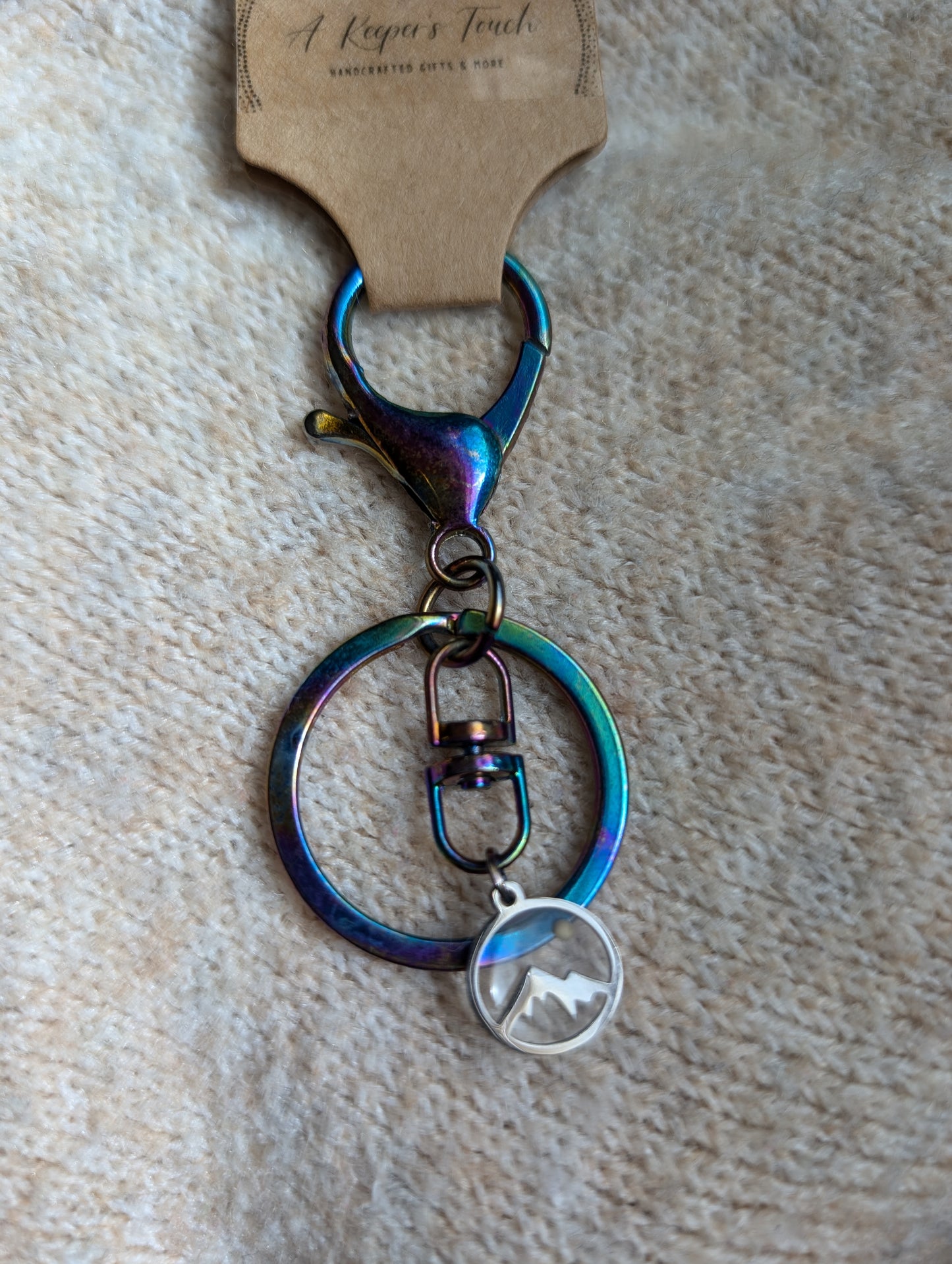 Iridescent metal keychain with mustard seed mountain charm