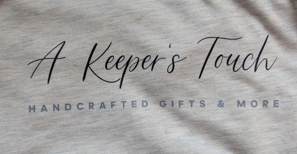A Keeper's Touch design on an oatmeal colored Medium T Shirt
