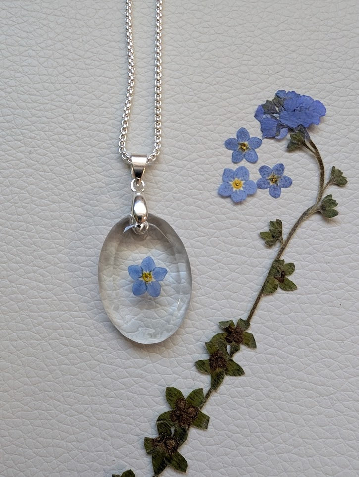 Clear gem; single forget-me-not, long silver chain