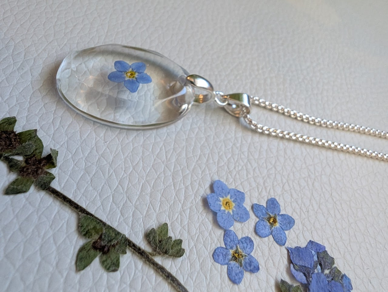 Clear gem; single forget-me-not, long silver chain