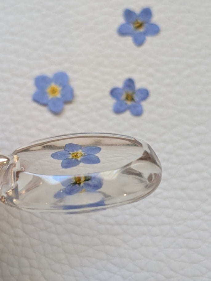 Clear gem; single forget-me-not, long silver chain