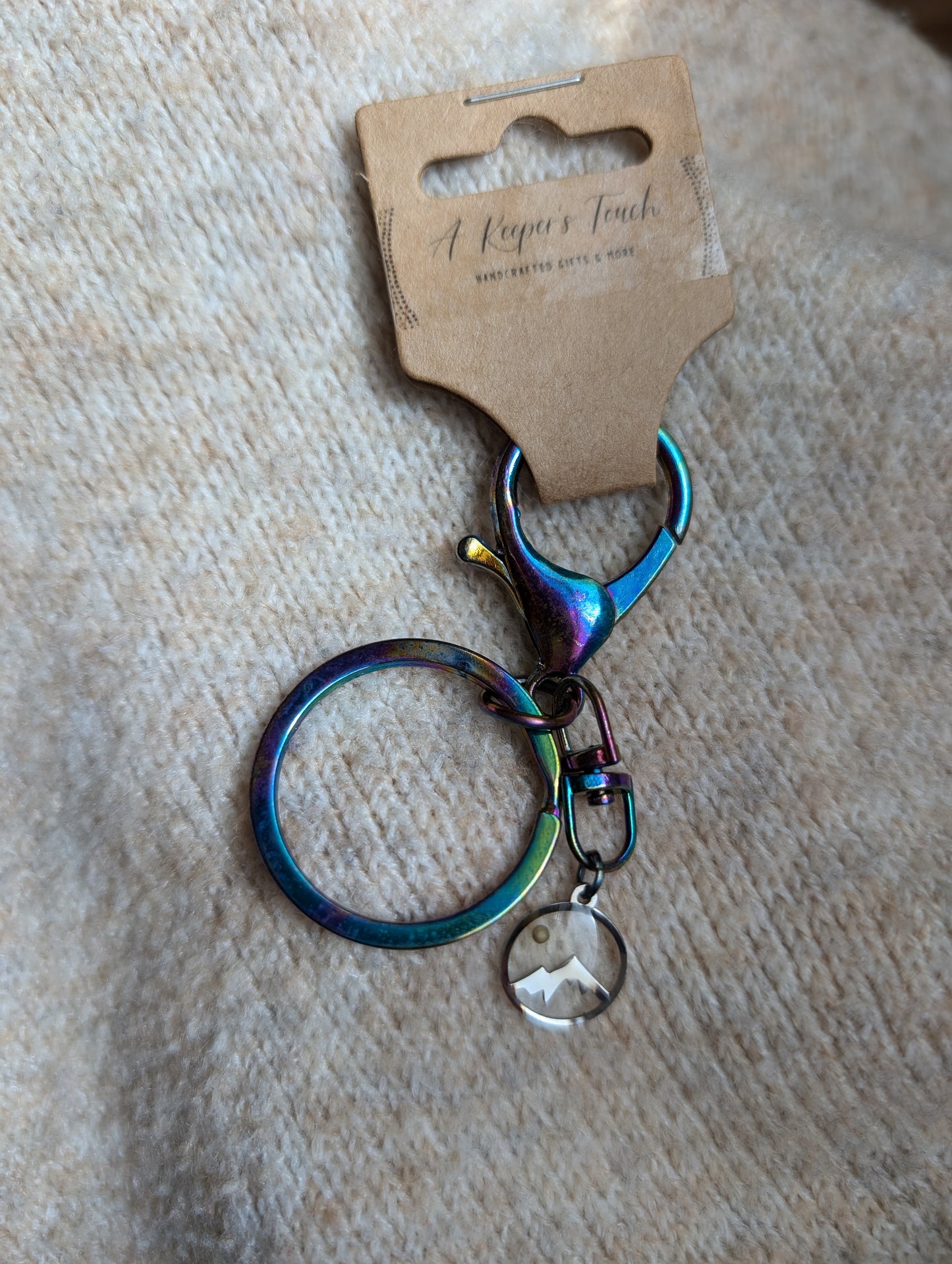 Iridescent metal keychain with mustard seed mountain charm